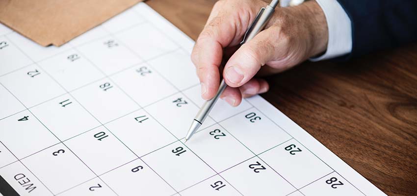 Man pointing to a date on a calendar.