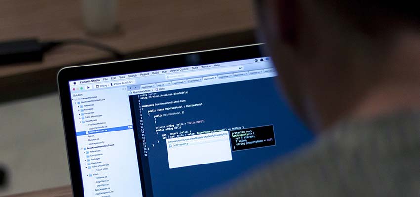 Man writing code on a laptop.