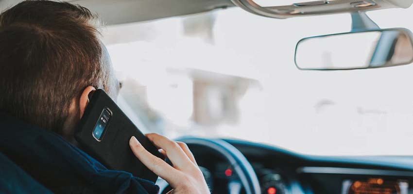 Man on a cellphone inside a car.