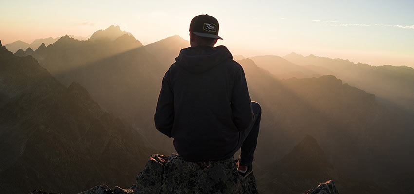 Man sitting in a mountain range.