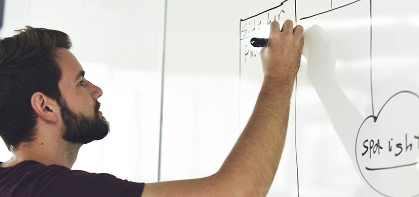 Man creating a flow chart on a whiteboard.