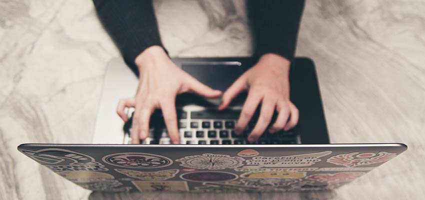 A person typing on a laptop computer.