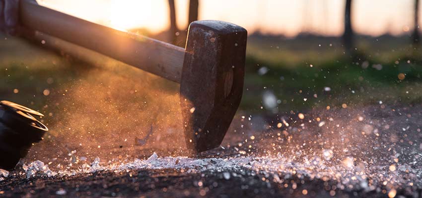 A hammer smashing glass.