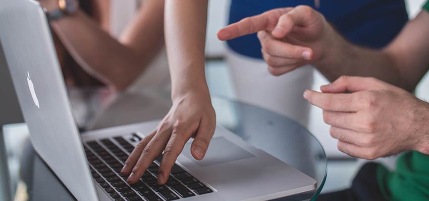 Freelance Design - People pointing at a laptop computer.