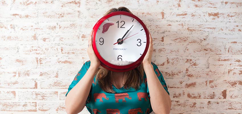 A person with a clock covering their face - Working from Home