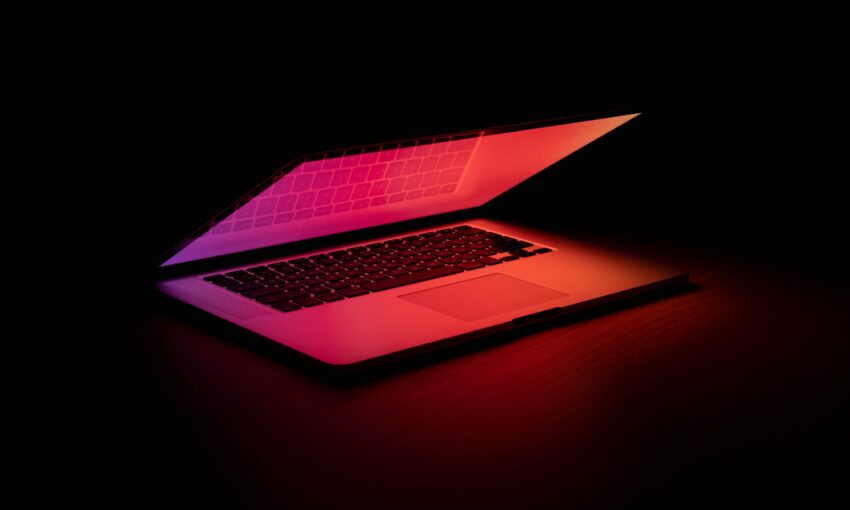 a lap top half open with a radiating gradient