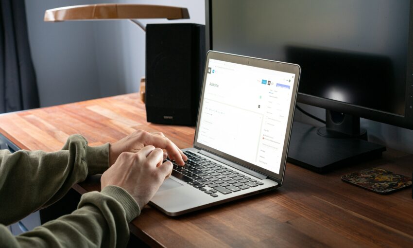 A person writing a new post in WordPress on a laptop
